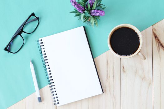 Still life, business, office supplies or education concept : Top view image of open notebook with blank pages and coffee cup on wooden background, ready for adding or mock up