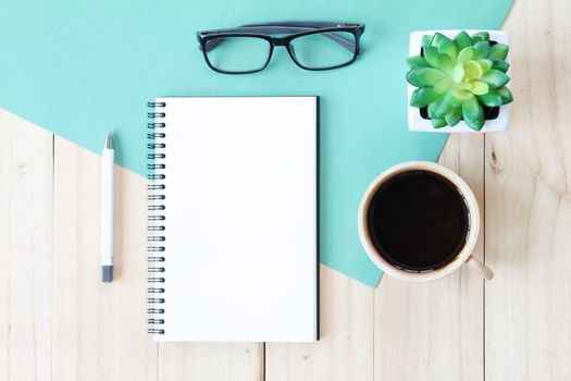 Still life, business, office supplies or education concept : Top view image of open notebook with blank pages and coffee cup on wooden background, ready for adding or mock up