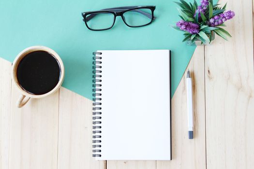 Still life, business, office supplies or education concept : Top view image of open notebook with blank pages and coffee cup on wooden background, ready for adding or mock up