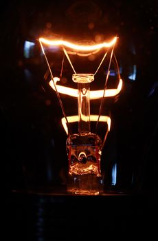 Extreme closeup of glowing light bulb on dark background