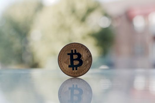 Digital currency physical gold bitcoin coin on the table near window
