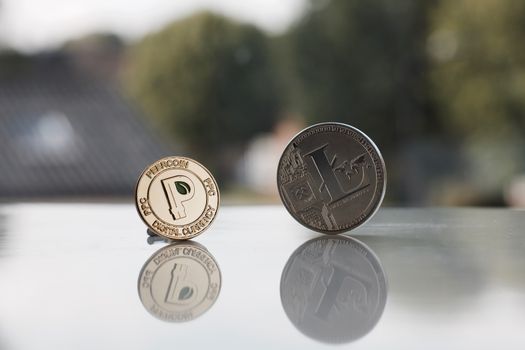 Digital currency physical small gold peercoin and big silver litecoin.