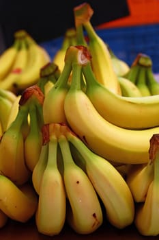 Heap of fresh yellow ripe bananas on retail market stall display, close up, low angle view