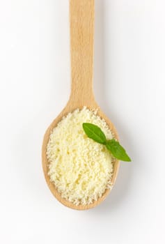 spoon of grated parmesan cheese with basil
