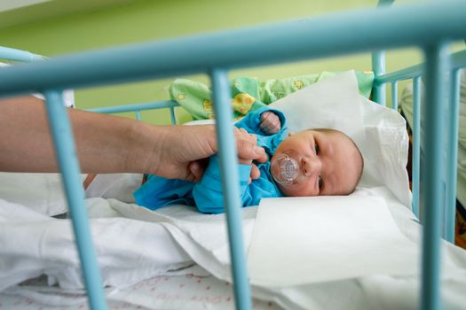 newborn baby infant in the hospital, the first hours of the new life, one days after birth