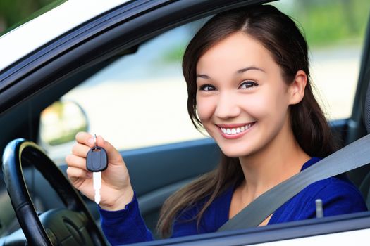 Beautiful young smiling happy girl shows the car key in her hand