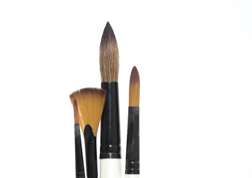 Various artists paint brushes of different sizes and shapes