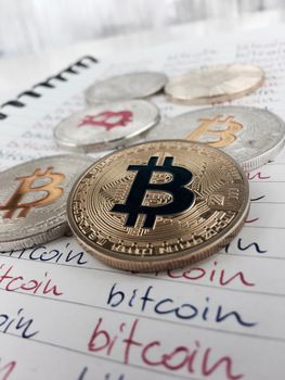 Cryptocurrency physical gold and silver bitcoin coins in notebook.