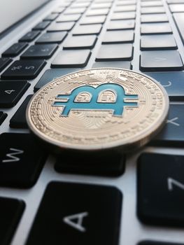 Cryptocurrency physical gold bitcoin coin on the black keyboard.