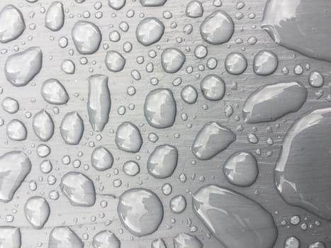 rain drops on on grey wooden bench 