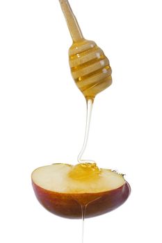 Honey flows down on a piece of apple on a white background