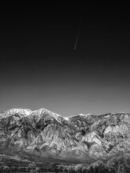 Black and white image of Snow capped mountains, blue sky, Desert landscape in California , USA