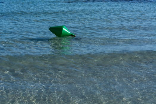 Green buoy as a shipping sign or sea sign in the sea.