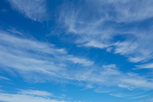 Fluffy white clouds on bright blue sky ideal for backgrounds