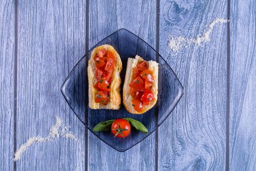 Italian bruschetta, a grilled crusty bread with tomatoes in pieces, basil and mozzarella cheese