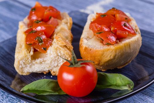 Italian bruschetta, a grilled crusty bread with tomatoes in pieces, basil and mozzarella cheese