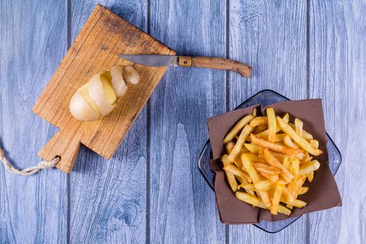 Potato peeled and cutted by hand with knife and french fries
