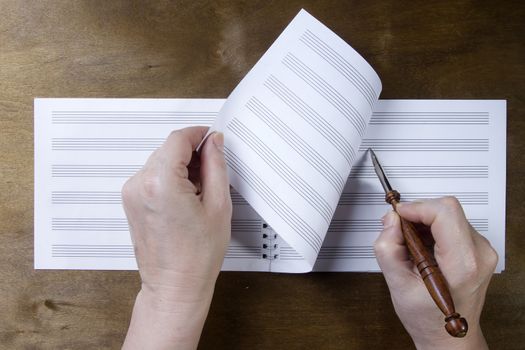 Hand writing in a note book on a wooden background