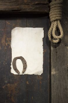 Rusty horseshoe and rope on an old wooden door