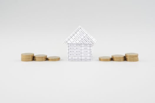 Paperwork as house place between step pile of gold coins with white background. 