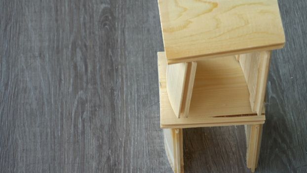 a young man breaks a small house of boards.