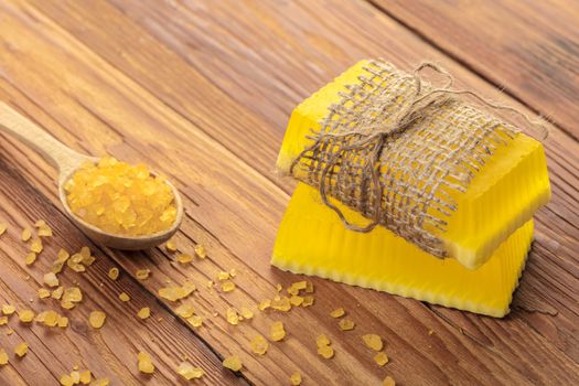 Yellow handmade soap and phyto salt on a wooden background