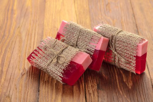 Red handmade fruit soap on a wooden background