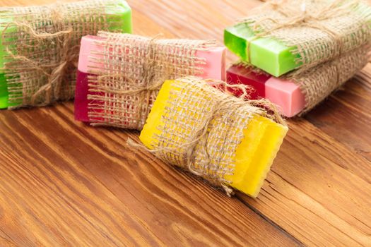 Colored handmade soap in a vintage packaging on wooden background