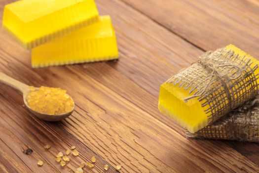 Yellow handmade soap and phyto salt on a wooden background