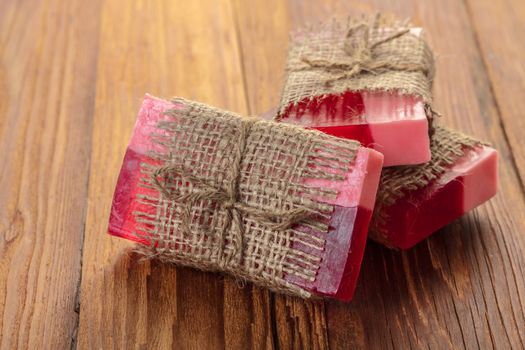Red handmade fruit soap on a wooden background