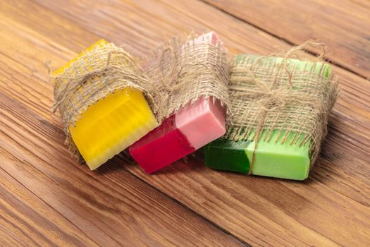 Colored handmade soap in a vintage packaging on wooden background
