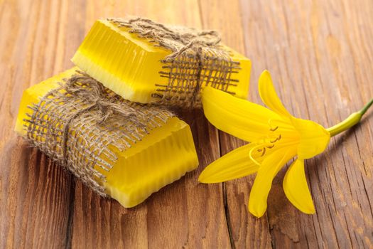 Yellow floral handmade soap on a wooden background