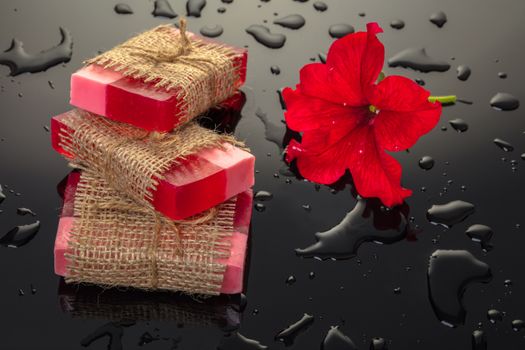 Handmade soap red with a flower petunia on black background