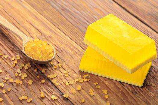 Yellow handmade soap and phyto salt on a wooden background