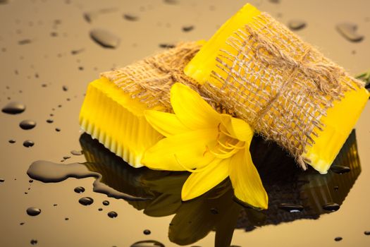 Handmade soap yellow on a dark background with drops of water