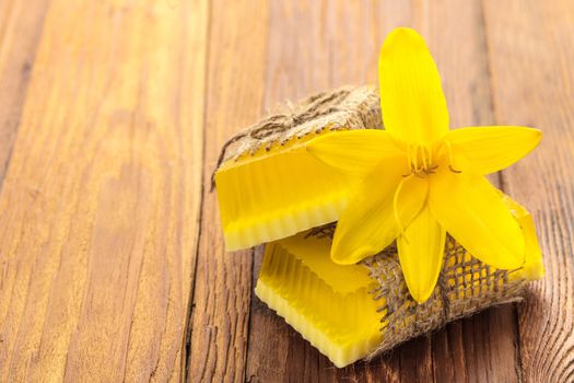 Yellow floral handmade soap on a wooden background