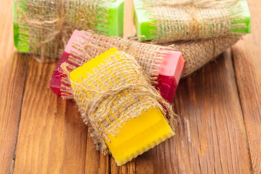 Colored handmade soap in a vintage packaging on wooden background