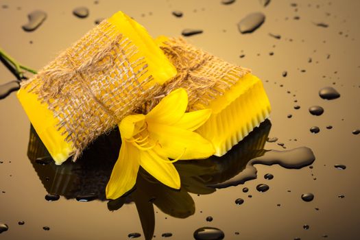 Handmade soap yellow on a dark background with drops of water