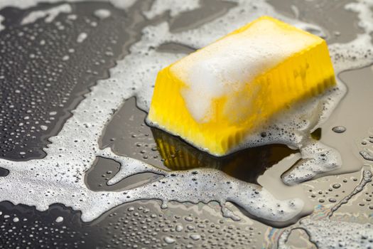 Handmade soap yellow on a black background with foam