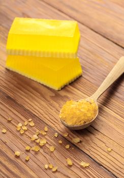 Yellow handmade soap and phyto salt on a wooden background