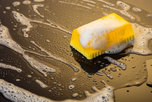 Handmade soap yellow on a black background with foam