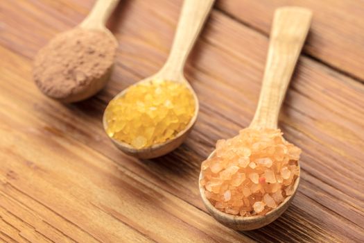 Spoons with phyto salt and clay on a wooden background