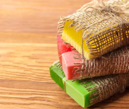 Colored handmade soap in a vintage packaging on wooden background