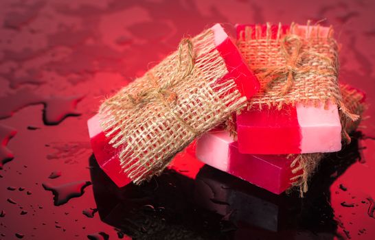 Handmade soap on red background and drops of water