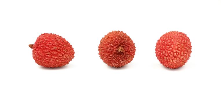 Three fresh red ripe litchee tropical fruits isolated on white background, detail close up in different perspectives, low angle view