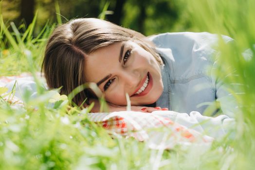 Pretty young woman laying in the grass and smiling