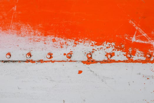 fragment of an iron surface is covered with orange and grey color paint, which has long been under the influence of different climatic conditions