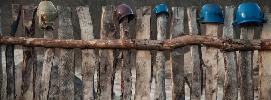 Old wooden boundary fence with nails on sunny day