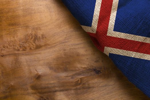 Flag Iceland on a wooden background of rough fabric.