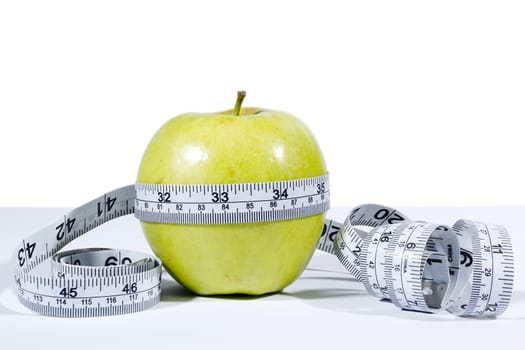 Green apple and measurement tape isolated on the white background